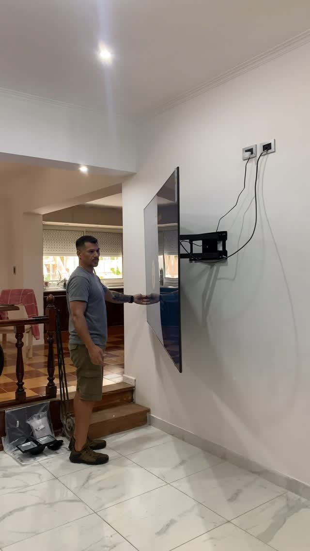 Técnico de INSTALATRON instalando una pantalla grande con precisión